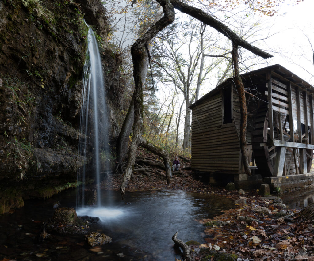 Old grist mill with waterfall spilling into the mill pond